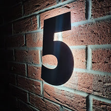 side picture of a door sign in the dark with light