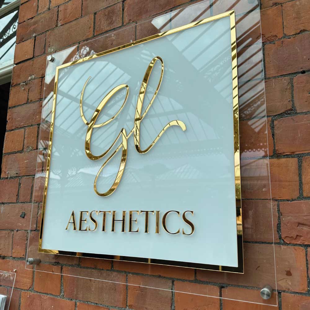 mirror gold and white acrylic salon sign on a brick wall