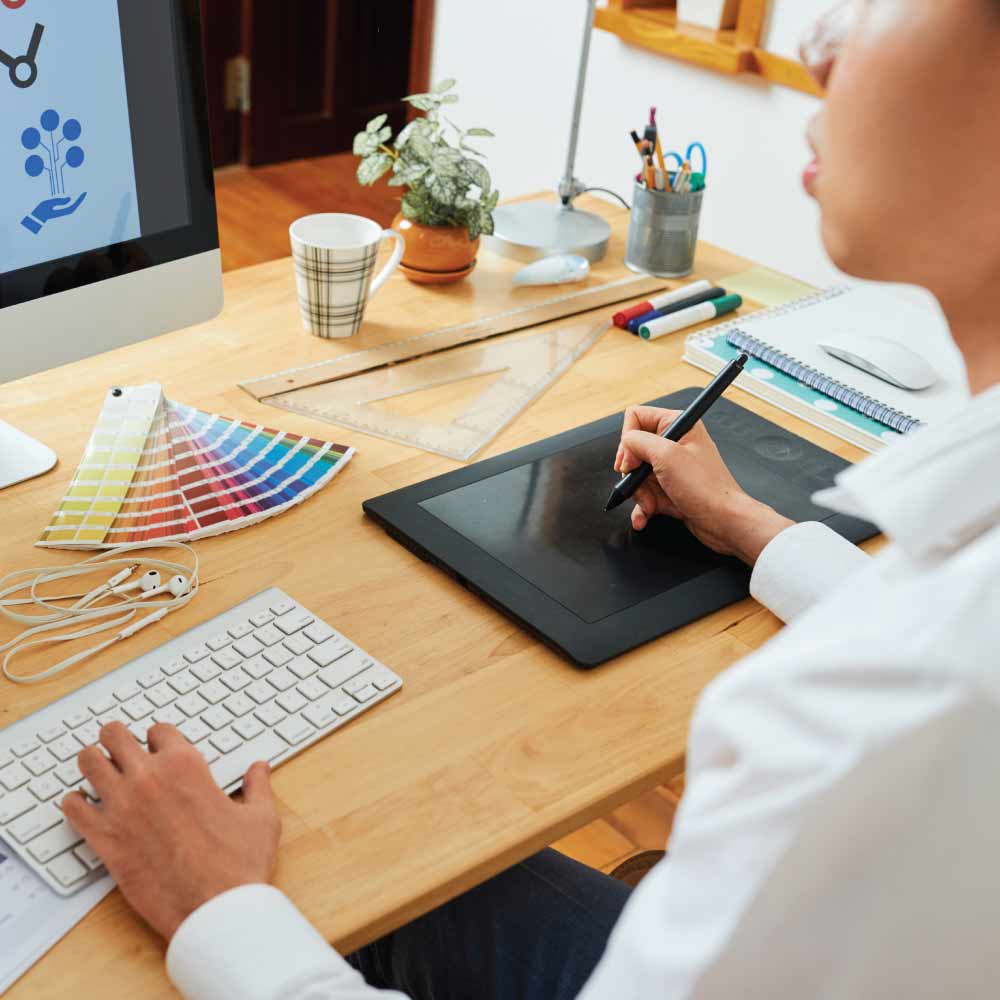 someone sitting at a computer working on a design