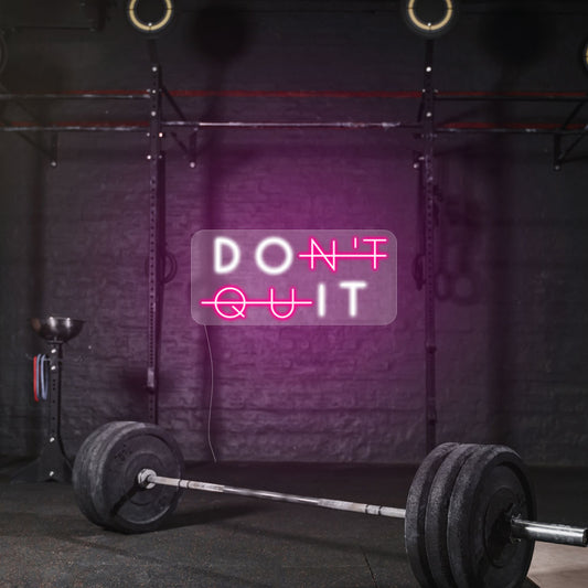 dont quit in a pink and white lights on a dark gym wall 