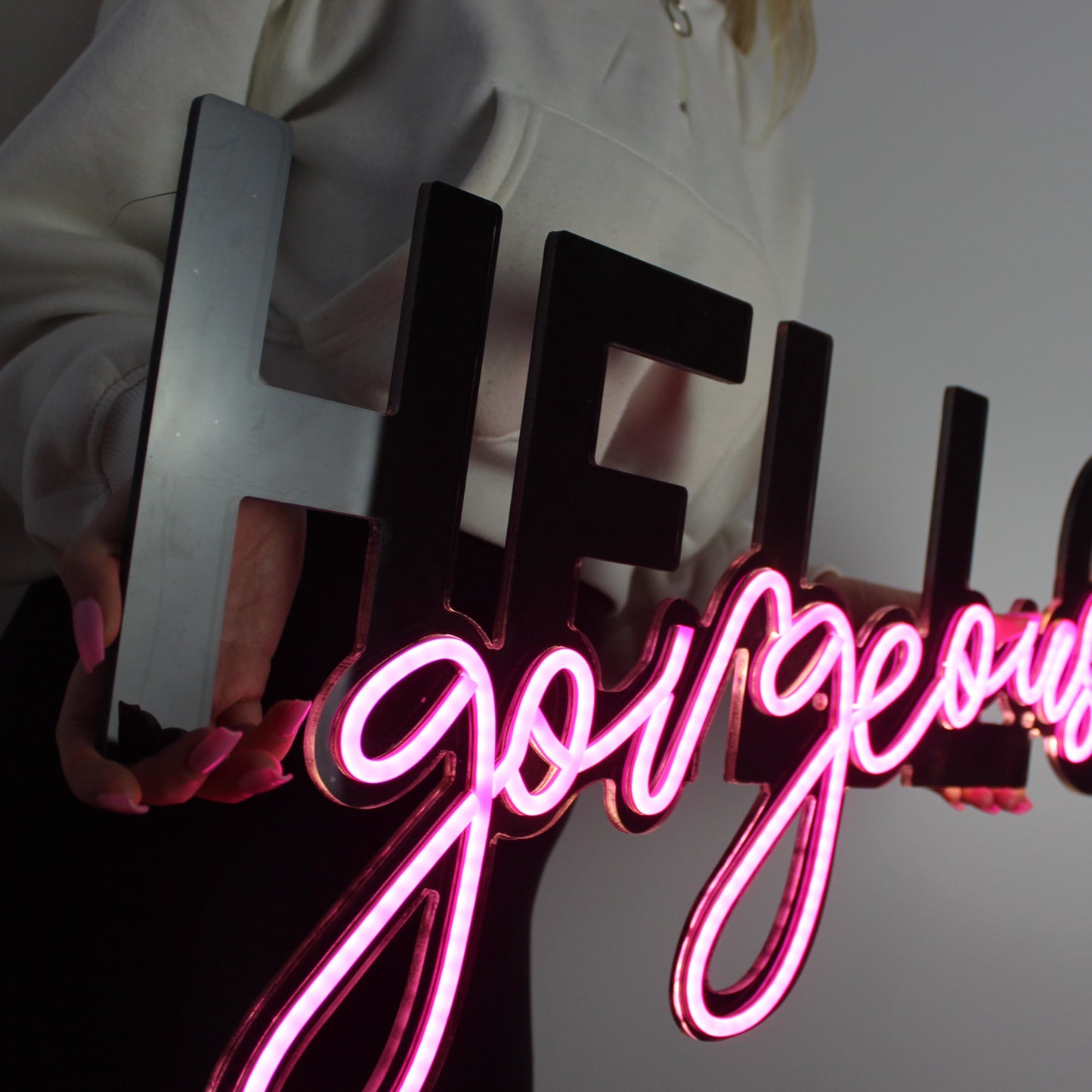 girl holding a neon sign saying hello gorgeous