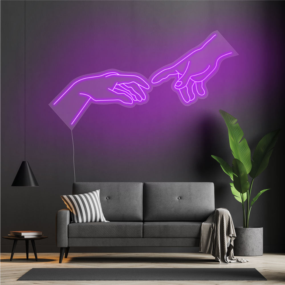 fingers touching neon sign above a sofa