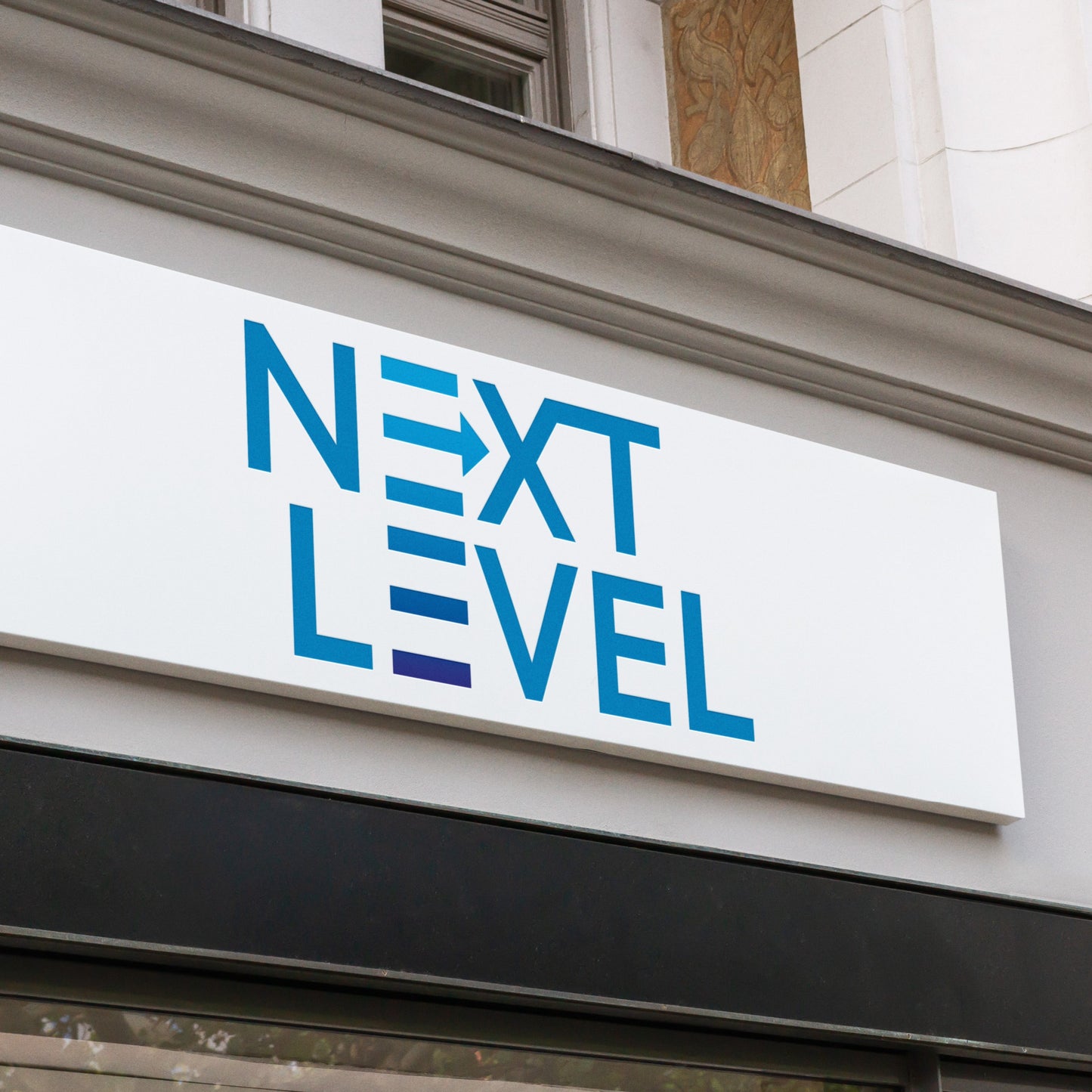 a next level tray folded sign with blue writing on a shop front