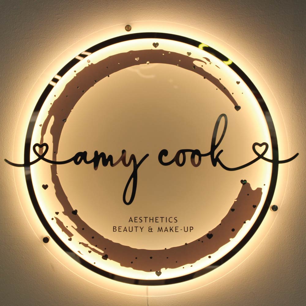 warm white light shining behind a circle shaped acrylic sign