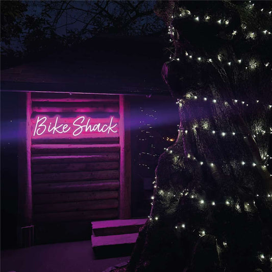 Bike Shack neon sign in a glowing pink halo light