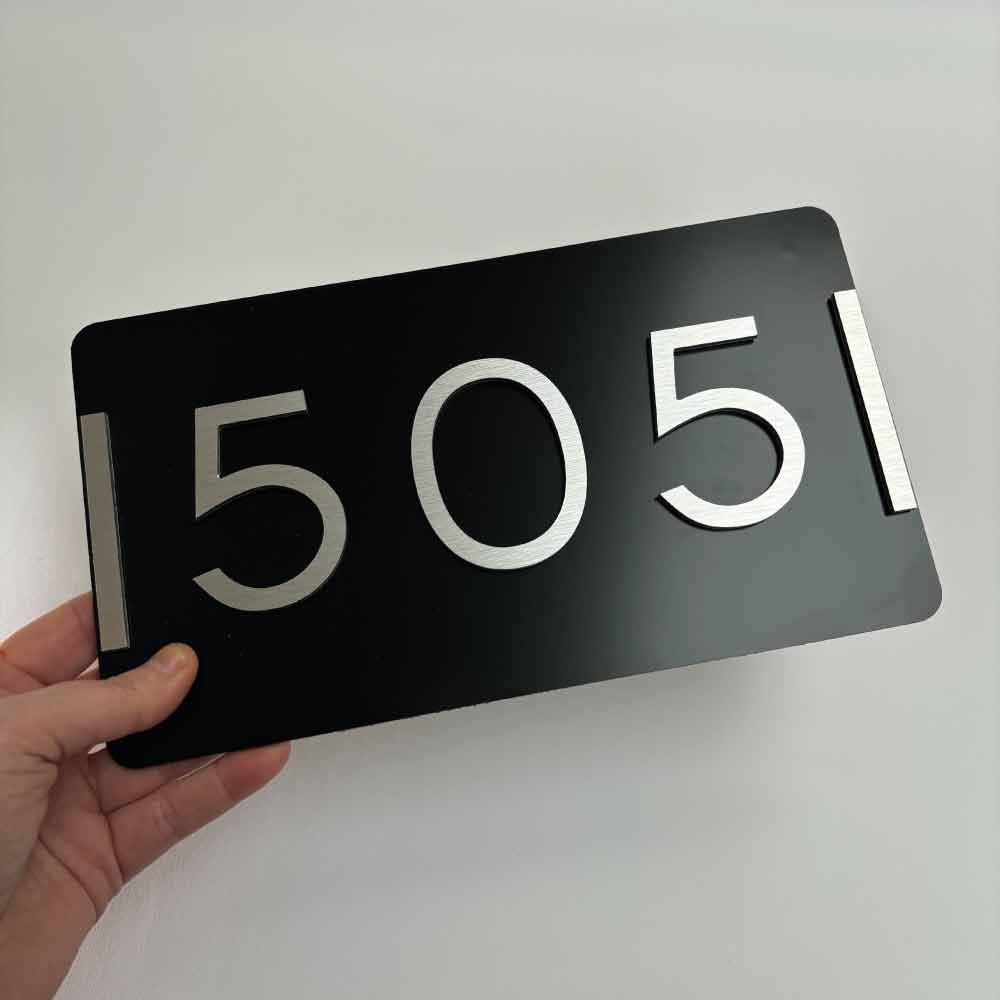 holding a house number address sign